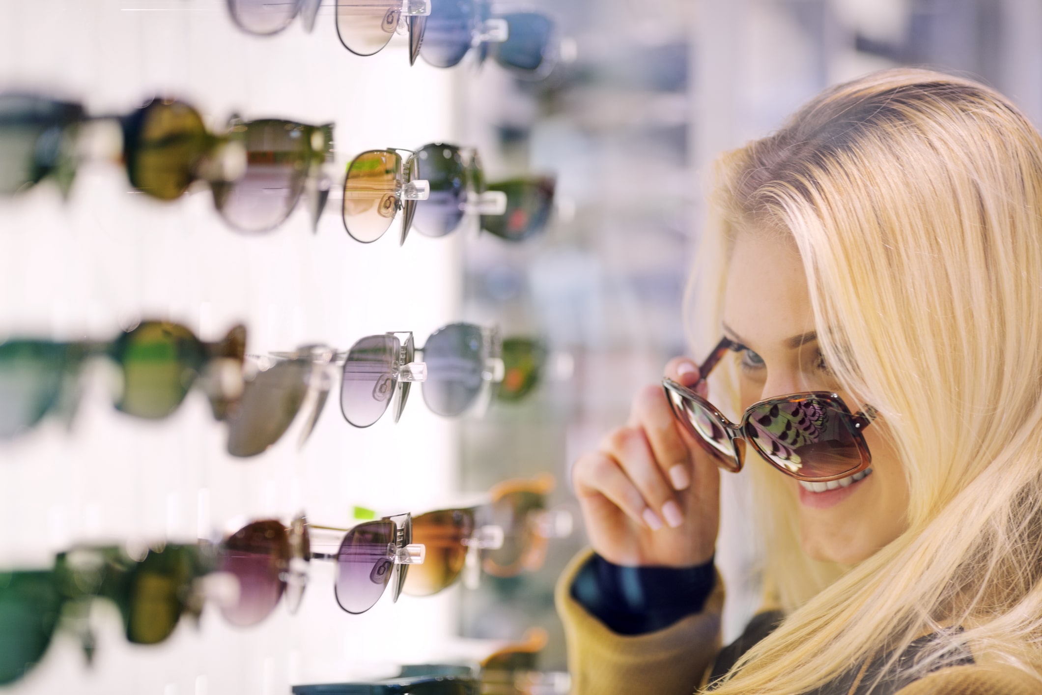 Teen girl trying sunglasses in store